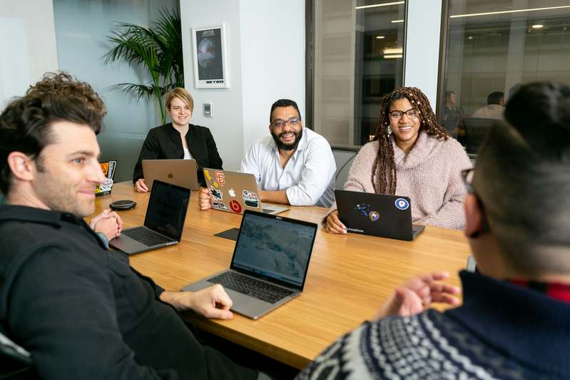 Split-screen illustration: left side shows marketer collaborating with sales team; right side shows content creation workflow with checklist, calendar, and analytics dashboard